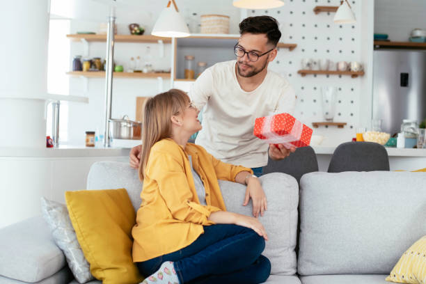istock Young man giving a gift box to his wife. 1253395229