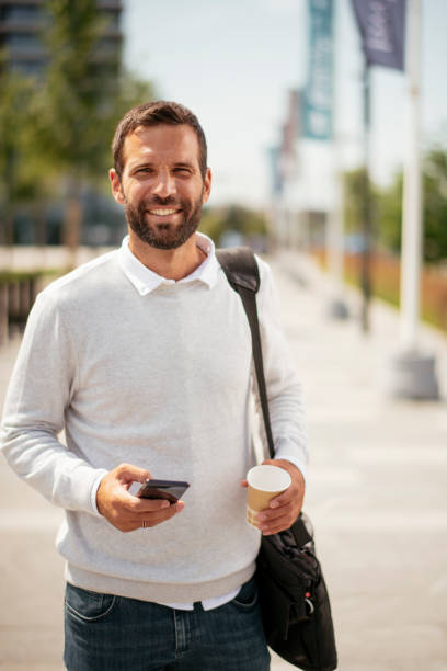 istock Handsome businessman using the phone outdoors. 1253395479