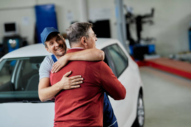 feliz mecánico y su saludo del cliente en el taller de reparación de automóviles. - customer auto repair shop car mechanic fotografías e imágenes de stock