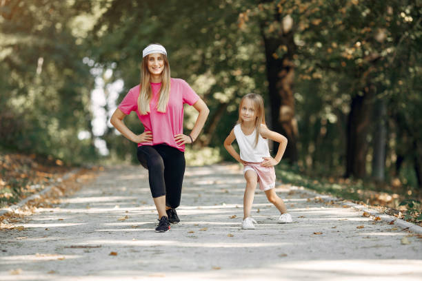istock Mother with daughter doing sport in a summer park 1253396552