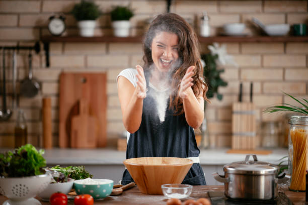 istock Beautiful girl playing with flour while cooking. 1253396705