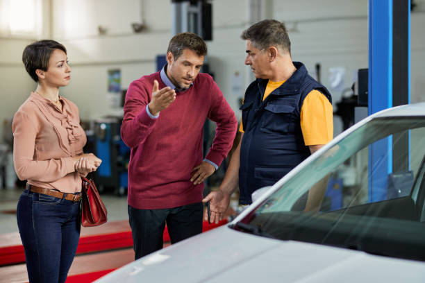 istock Auto repairman discussing with a couple at car workshop. 1253397623