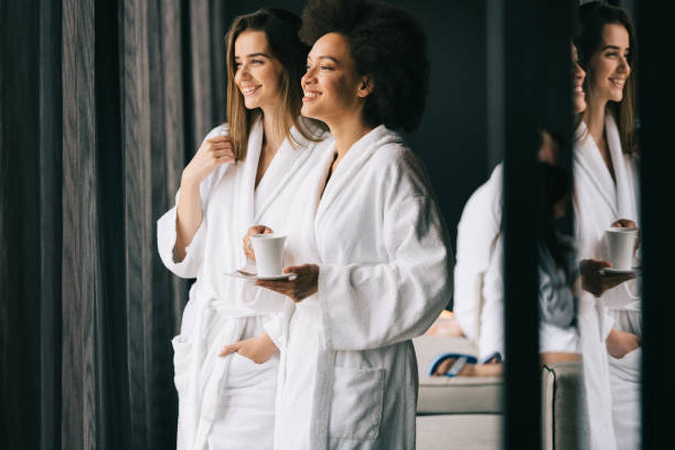 kobiety relaksujące i pijące herbatę w szatach podczas weekendu wellness - bathrobe health spa spa treatment couple zdjęcia i obrazy z banku zdjęć