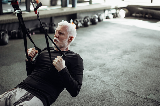 Senior man exercising at gym.