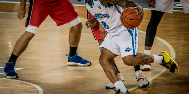 istock Basketball players chasing for ball 1253403933