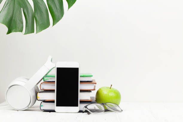 Workplace with smartphone, supplies and apple