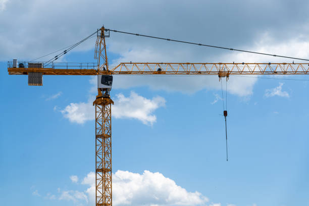 istock Construction of a building with a construction crane against the blue and cloudy sky. 1253408123