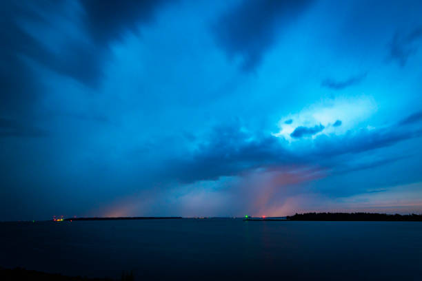 Lightning in the dark night sky over a lake during summer in Flevoland, The Netherlands