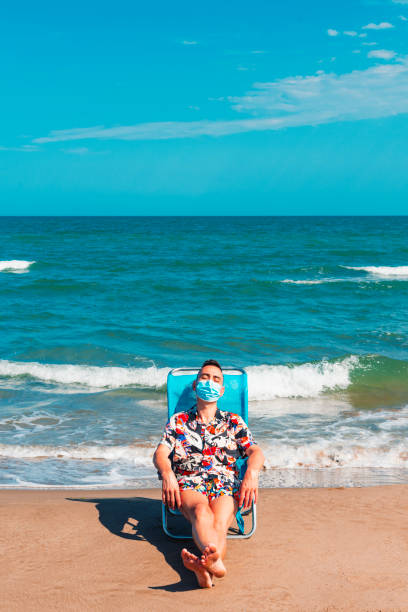 istock man wearing a surgical mask on the beach 1253409369