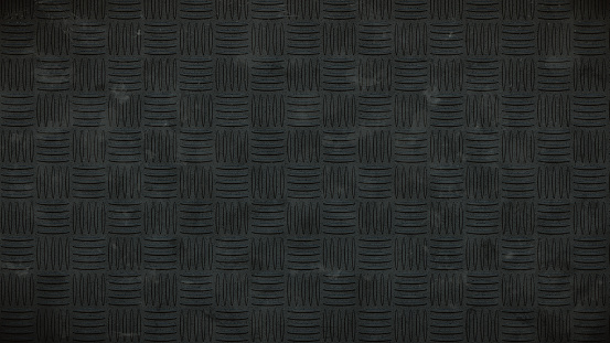 Dirty dark studded plastic rubber floor plates background with rough pattern, directly above view