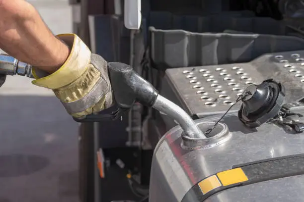 A fuel gun is stuck in the fuel tank of a truck during refuelling