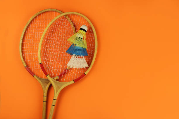 istock badminton rackets and shuttlecocks on a bright orange background. Copy space for your text 1253417489