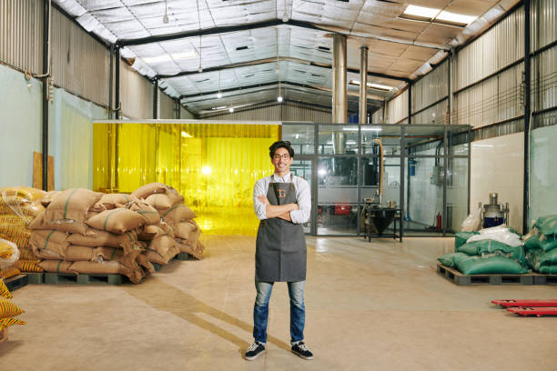 zuversichtlich lächelnde kaffeerösterei besitzer - coffee sack bag warehouse stock-fotos und bilder