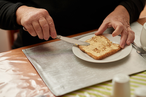 Woman making peanut butter and banana sandwich for breakfast with avocado smoothie at home