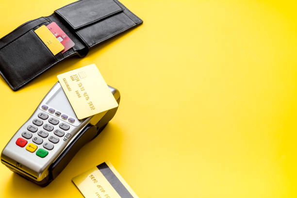 istock Payment by credit card. Terminal on yellow table copy space 1253423667