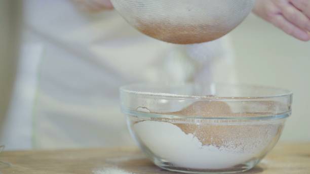 istock Chef sifting a cocoa powder to bowl with flour 1253426256