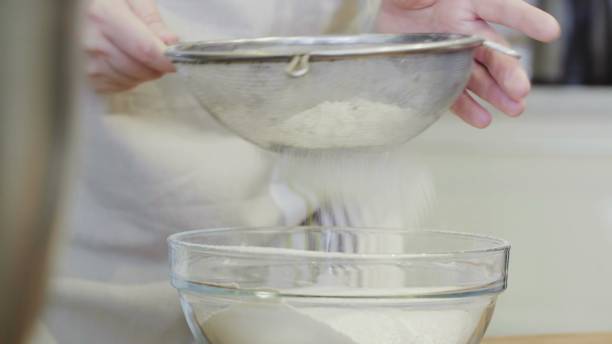istock Close up of sifting flour through sieve. 1253426264