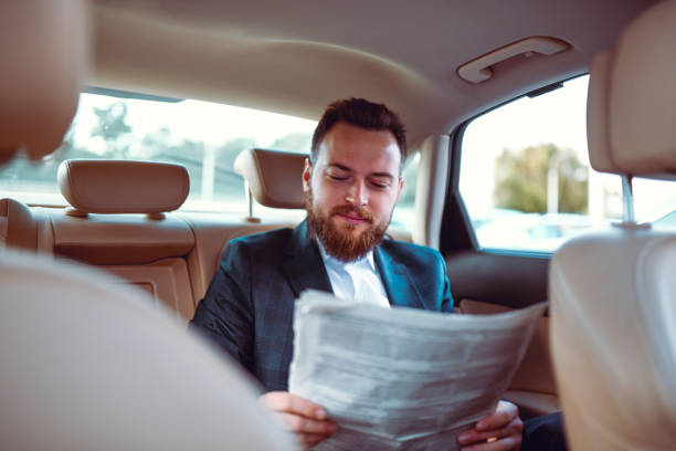istock Handsome Businessman Reading Newspaper While Traveling 1253426379