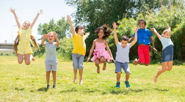 istock Schoolchildren  jumping and smiling together in park 1253426577