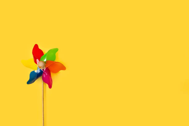 istock A colored pinwheel on a yellow background 1253426641