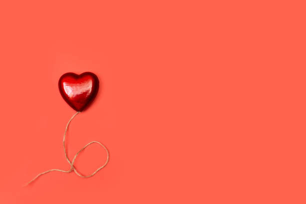 istock A plastic red heart on a red background 1253427069