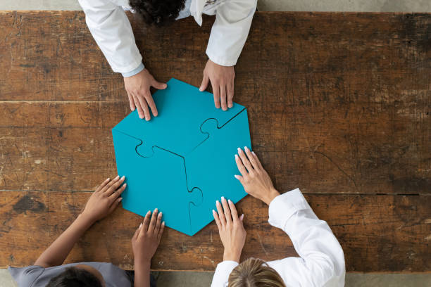 istock Professionals assembling 3 par puzzle piece, aerial view 1253428951