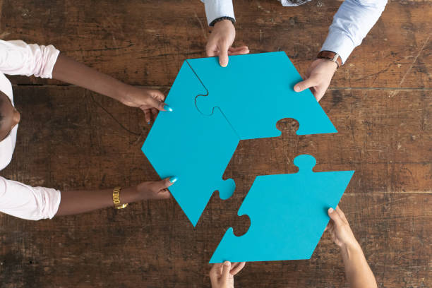 istock Professionals assembling 3 par puzzle piece, aerial view 1253428953