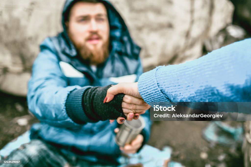 Female Offering Support For Homeless Male On Street A Helping Hand Stock Photo
