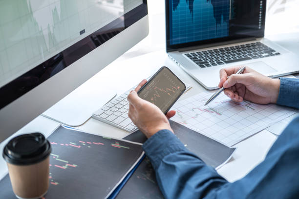 istock Stock exchange market concept, stock broker looking at graph working and analyzing with display screen, pointing on the data presented and deal on a exchange, Businessman trading stocks online 1253431047