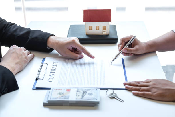 Estate agent broker pointing contract form to client signing agreement contract real estate with approved mortgage application form, buying or concerning mortgage loan offer for and house insurance. agente de bienes que apunta el formulario de contrato al cliente firma contrato contrato de bienes raíces con formulario de solicitud de hipoteca aprobado, compra o con respecto a la oferta de préstamo hipotecario y la vivienda de seguros
