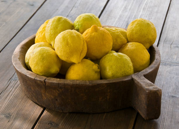 Freshly picked organic lemons in a rustic wooden bowl