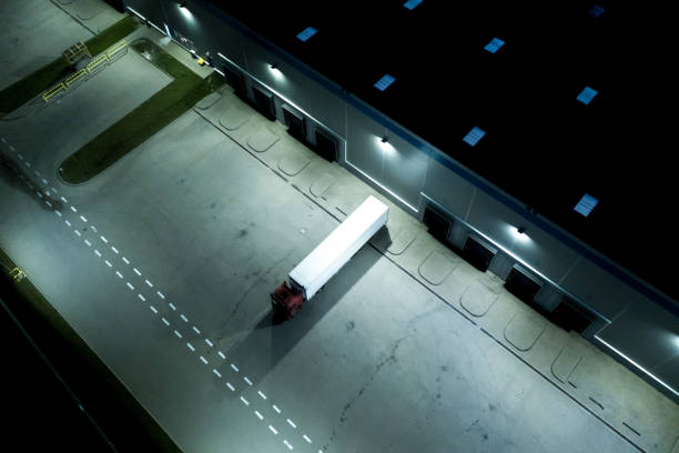 istock Night Modern logistics center, white van and trailers standingon ramp. Aerial View 1253433719