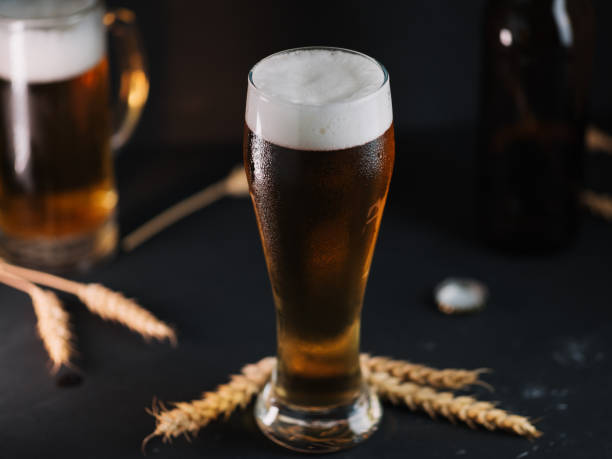 istock Cold light beer in a glass on a dark table. 1253434166