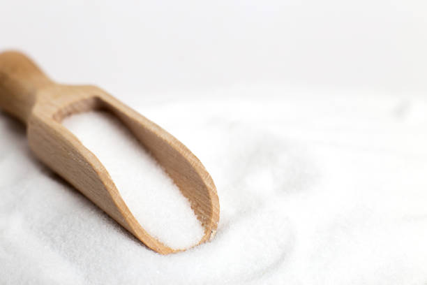 istock Salt grain in wooden spoon top view on a white background , flat lay. 1253434260