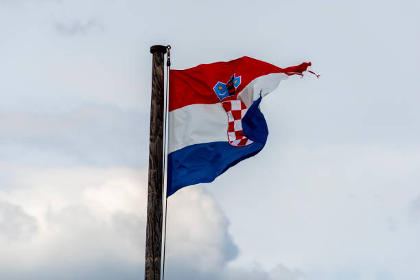 istock Croatia Flag is Waving Against Blue Sky 1253436176