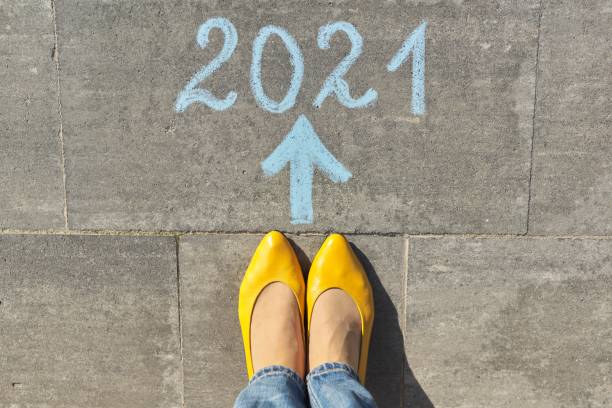istock 2021 year arrow forward concept, top view on woman legs and text 1253437541