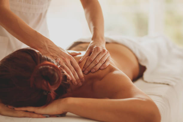 istock Massage therapist giving reflexology back massage to a female client 1253437553