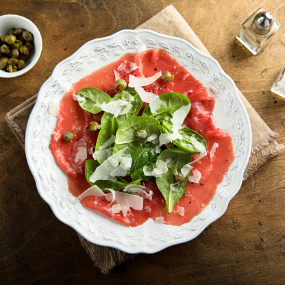 Homemade beef carpaccio with arugula and cheese