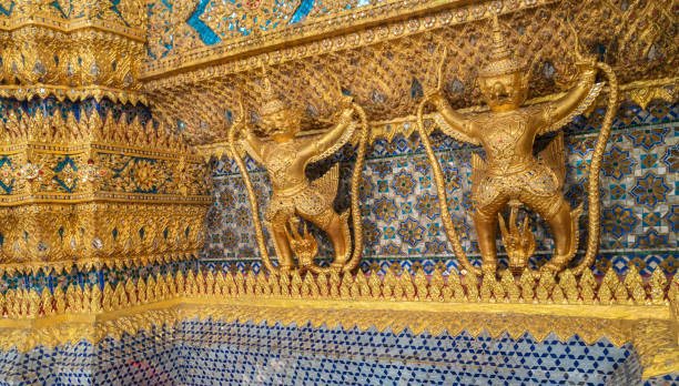 garudas et nagas sur les décorations extérieures du temple wat phra kaew grand palace bangkok thaïlande. - garuda bangkok thailand gold photos et images de collection