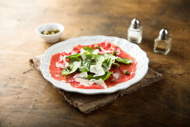 Beef carpaccio Homemade beef carpaccio with arugula and cheese carpaccio parmesan cheese beef raw stock pictures, royalty-free photos & images