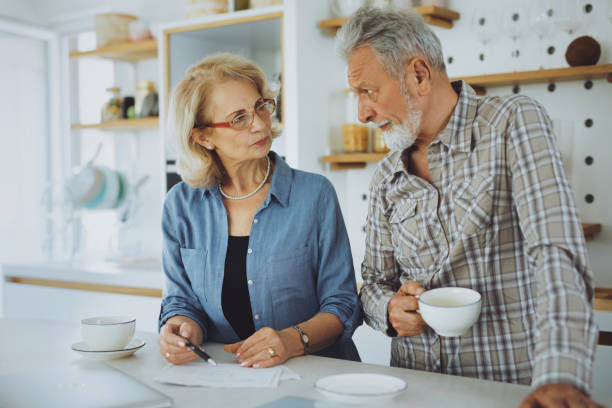 istock Senior couple checking their bills over tea in the kitchen 1253440965