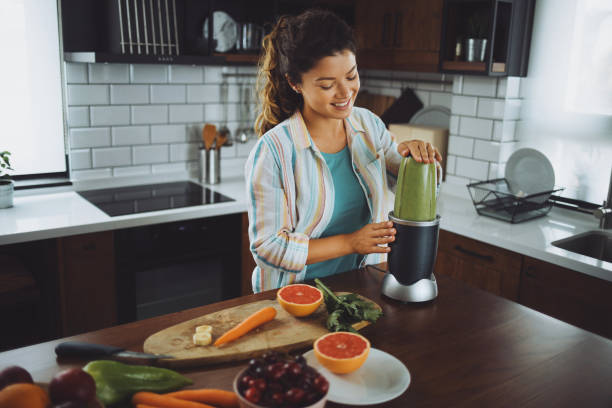 istock Young woman preparing a green smoothie at home 1253441275