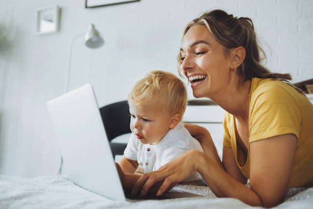 istock Caring mother and son using laptop on bed 1253442135
