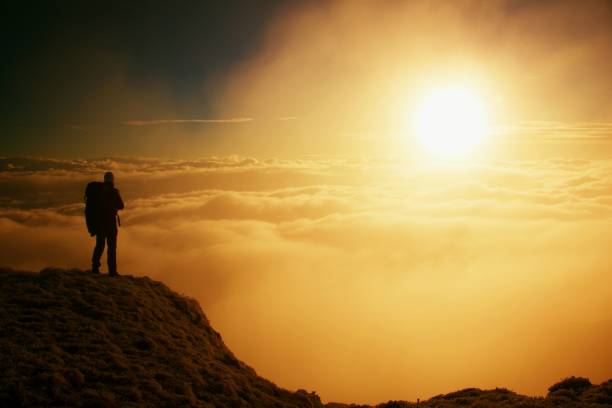 istock Silhouette Man Standing On Rock Against Sky During Sunset 1253446248