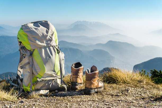 Hiking equipment. Backpack and boots on top of mountain Corno di Tres, Tresner Horn, Trentino, South Tyrol, Val di Non, Val d'Adige, Alps, Italy. stock photo
