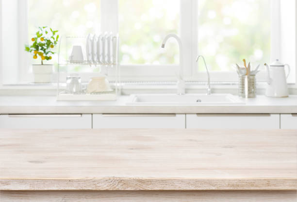 istock Wooden table on blurred backgrounds of kitchen white sink window 1253450940