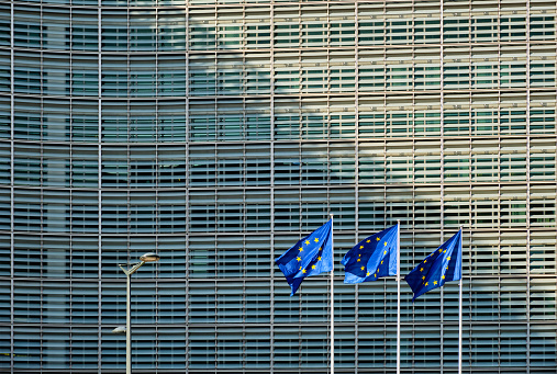 European Commission Brussels - European Union Flag EU Flags side by side in the Wind- European Union Flags in a row in front of the European Commission Headquarter blowing in the wind. Hasselblad 102 MPixel X2D 16:9 Crop.  Brussels, Belgium, Europe