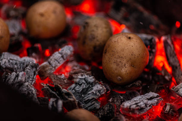 ジャガイモはグリルで赤熱炭で焼かれます - redhot ストックフォトと画像