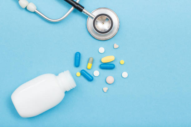 istock White bottle with different pills and phonendoscope on blue background 1253454930