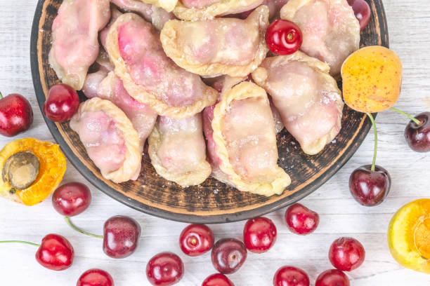 istock Ready-to-eat dumplings with cherries on brown plate. 1253456091